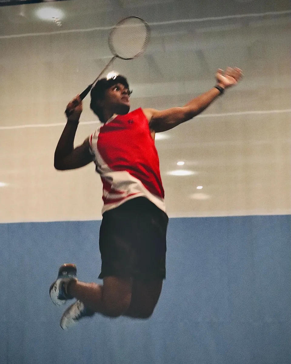 Pranav Vallathoor leaping to play an overhead shot, racket raised